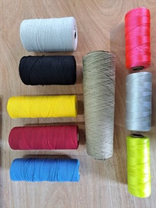 Seven bales of different coloured polyester yarn.